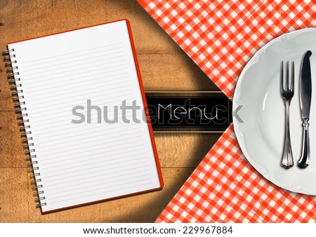 Menu with Notebook and White Plate / Food menu with white plate, silver cutlery and empty notebook on wooden background with tablecloth and horizontal black band
