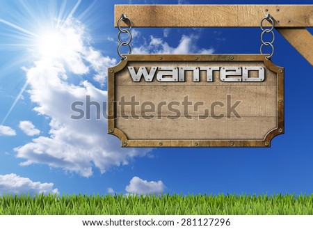 Wanted - Wood and Metal Sign with Chain. Wooden sign with planks and metal frame with text Wanted. Hanging from a metal chain on a pole on blue sky with clouds and sun rays
