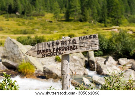 Sign Sale Fresh Cheeses in Mountain - Italy / Wooden directional sign with italian text Sale butter, cheeses and ricotta - Alm. Trentino Alto Adige, Italy