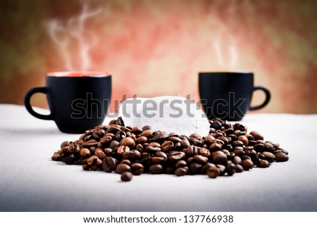 steaming coffee and capsule with coffee beans