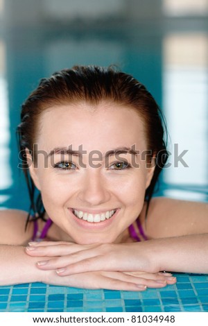 Beautiful smiling girl in a swimming pool with a copy space at the top of the photo