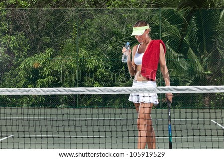 portrait of young beautiful woman playing tennis in summer environment