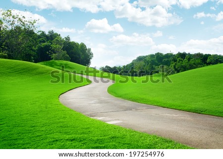 panoramic view of nice green hill and path on blue sky background