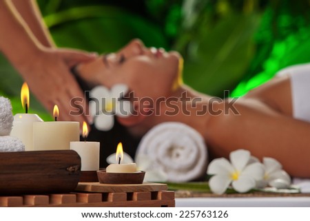 portrait of young beautiful woman in spa environment. focused on candles