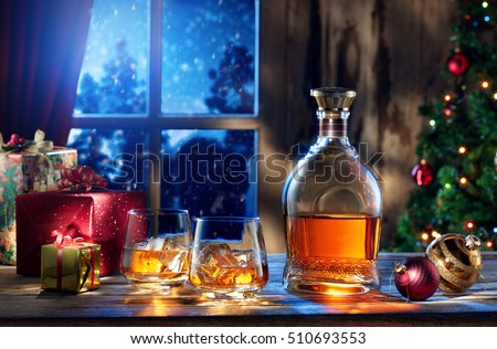 close up view  of two glasses with whiskey and gift boxes on color back