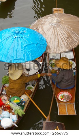 view of two boats with big umbrellas up on it  in Damnoensaduak, Thailand