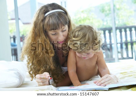 High key portrait  of young mother reading a book for her baby