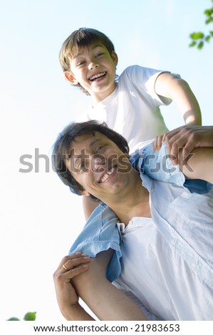 Portrait of young happy father getting  busy with his son