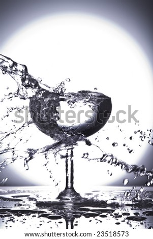 Close up view of margarita glass getting splashed on gray back
