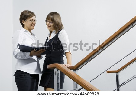 Portrait of young pretty women having  conversation  in office environment