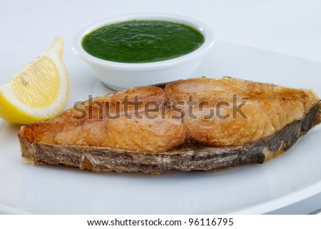 close up view of nice  fried fish with lemon on white back