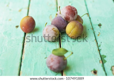 group of plums on rustic turquoise surface