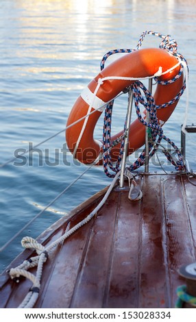 Orange life buoy in the yacht deck in marina