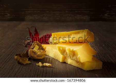 Ripened cheese and a walnut on a rustic background with warm lighting mood