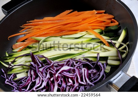 Sliced carrots, zucchini and red cabbage in a pan