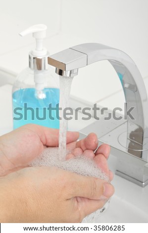 Washing hands with water and liquid soap