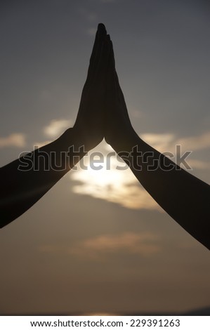 Hand coming together in shadow