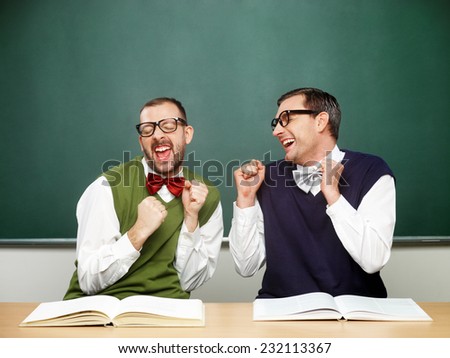 Two male nerds in ecstasy in front of blackboard