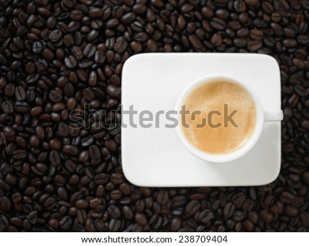 A cup of cafe latte with coffee beans