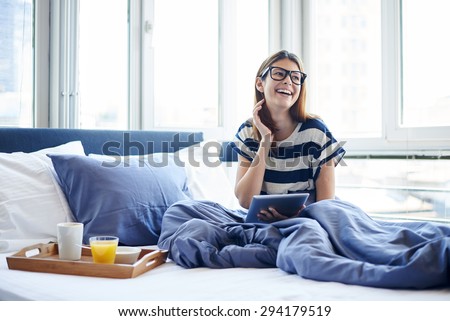 Breakfast in bed for young beautiful woman with glasses