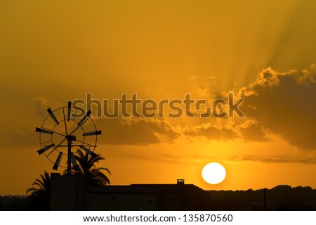 Sunset on the island of Mallorca, the sun setting behind one of the may windmills on the island.