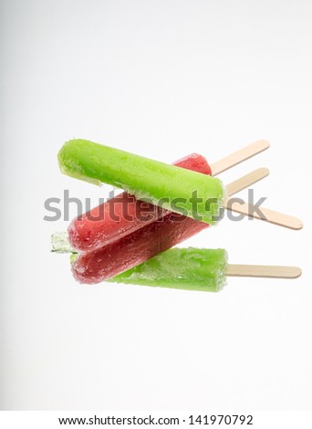 Frozen colorful fruit flavored ice pop desserts with mirror reflection.