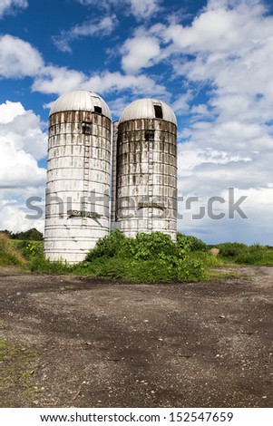 Royalty-free stock image of two old farm silos on an over grown farm in Vermont on a summer day.