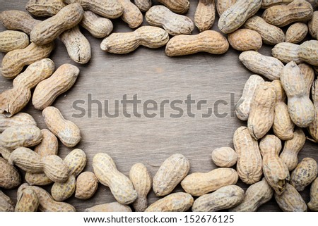 A border of roasted peanuts with copy space in the middle.