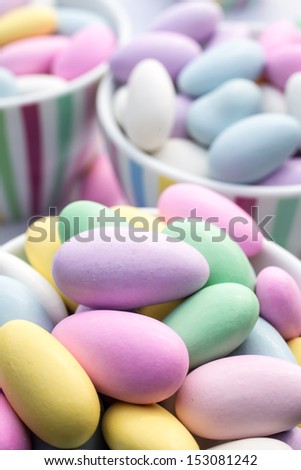A candy buffet at a party with assorted pastel colored jordan almond candy.
