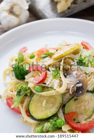 Pasta dish with vegetables and a parmesan cheese sauce.