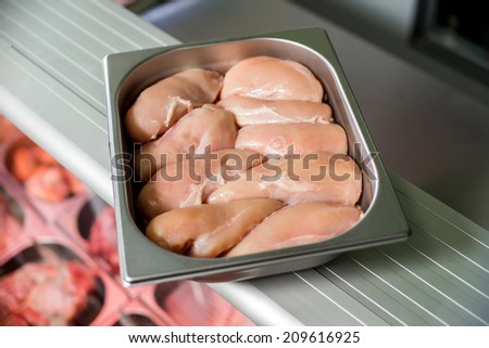 raw chicken breast in a deep iron cruets laid out in two rows