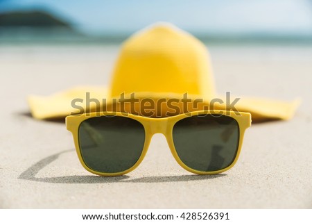 Yellow glasses and hat on the beach