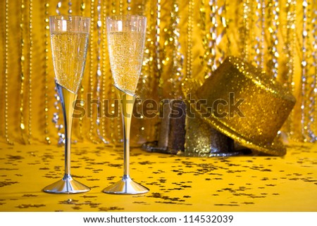 Two flutes of bubbling champagne are against a sparkly background.
