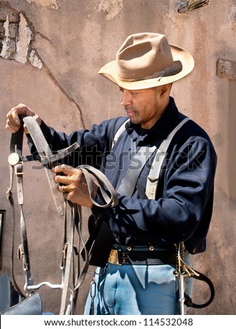 One of the New Buffalo Soldiers inspects saddle gear at the Santa Clarita, CA Cowboy Festival.
