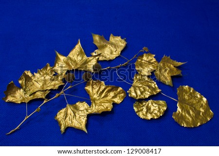 Bright gold leaves are patterned against a blue woven background.