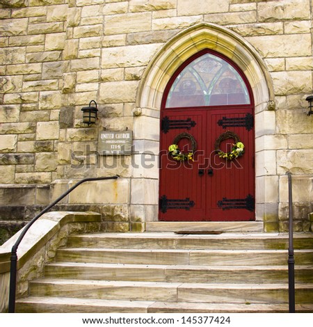 Stone steps lead to the red front doors of the United Church of Christ in Dorset, Vermont.
