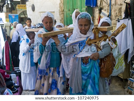 JERUSALEM - APRIL 13 : Ethiopian Christian pilgrims carry across along the Via Dolorosa in Jerusalem on April 13 2012 commemorating the path Jesus carried his cross on the day of his crucifixion