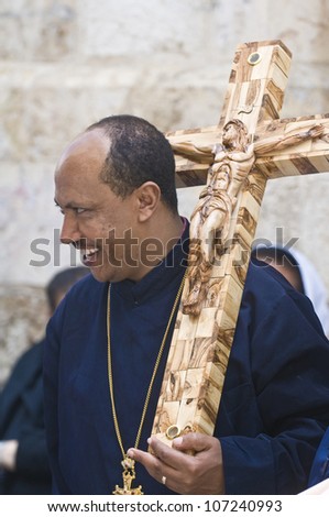 JERUSALEM - APRIL 13 : Ethiopian Christian pilgrim carry across along the Via Dolorosa in Jerusalem on April 13 2012 commemorating the path Jesus carried his cross on the day of his crucifixion