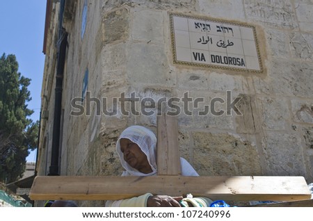 JERUSALEM - APRIL 13 : Ethiopian Christian pilgrim carry across along the Via Dolorosa in Jerusalem on April 13 2012 commemorating the path Jesus carried his cross on the day of his crucifixion