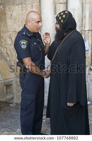 JERUSALEM - APRIL 13: Coptic priest meet with Israeli police officer at the church of the Holy Sepulcher in Jerusalem Israel during Good Friday on April 13 2012