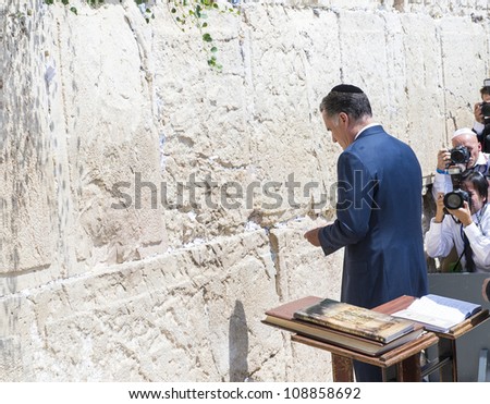 JEUSALEM - JULY 29 :  US Republican presidential candidate Mitt Romney places a message written on paper in the stones of the Western wall during his visit to Jerusalem, Israel on July 29, 2012