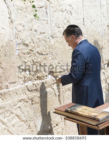 JERUSALEM - JULY 29 :  US Republican presidential candidate Mitt Romney places a mesage written on paper in the stones of the Western wall during his visit to Jerusalem, Israel on July 29, 2012