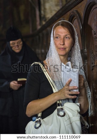 JERUSALEM - AUGUST 25: Unidentified pilgrim prays in the Tomb of Mary in Gethsemane during the feast of the Assumption of the Virgin Mary on August 25,2012 in old Jerusalem, Israel