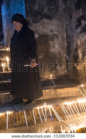 JERUSALEM - AUGUST 25 : Unidentified nun prays in the Tomb of Mary in Gethsemane during the feast of the Assumption of the Virgin Mary on August 25 2012 in old Jerusalem Israel