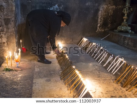 JERUSALEM - AUGUST 25 : Unidentified nun prays in the Tomb of Mary in Gethsemane during the feast of the Assumption of the Virgin Mary on August 25 2012 in old Jerusalem Israel