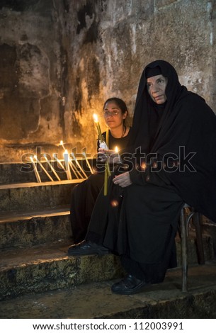 JERUSALEM - AUGUST 25 : Unidentified nuns prays in the Tomb of Mary in Gethsemane during the feast of the Assumption of the Virgin Mary on August 25 2012 in old Jerusalem Israel