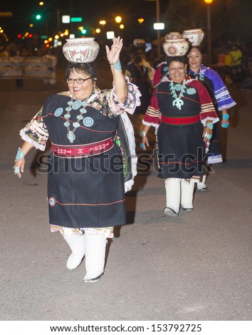 GALLUP , NEW MEXICO - AUG 08 : Native American women with traditional costume participates at the annual Inter-tribal ceremonial night parade on August 08 , 2013 in Gallup New-Mexico