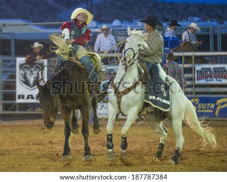 LOGANDALE , NEVADA - APRIL 10 : Cowboy Participating in a Bucking Horse Competition at the Clark County Fair and Rodeo a Professional Rodeo held in Logandale Nevada , USA on April 10 2014