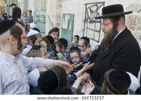 JERUSALEM - APRIL 05 : An Ultra Orthodox Jew man handing out food to poor children in Jerusalem Israel on April 05 2012 providing food to the poor is one of the customs of Passover