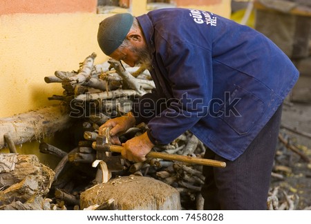 Turkish old man working in the yard with axe